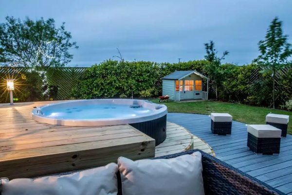 a round artesian spa with hot tub privacy fences and bushes
